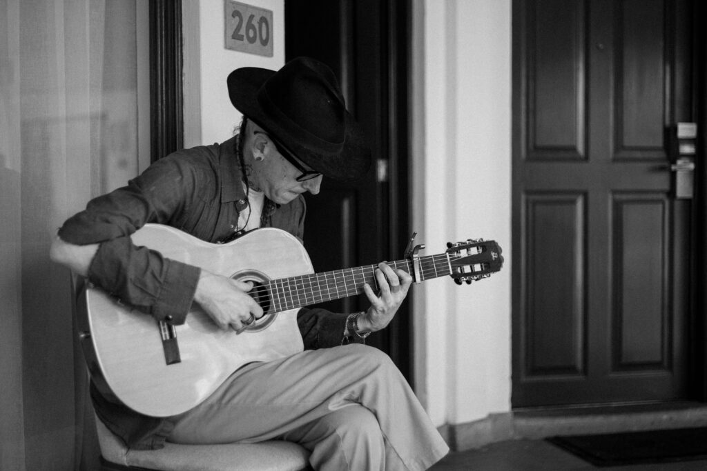 Hombre con sombrero y guitarra sentado