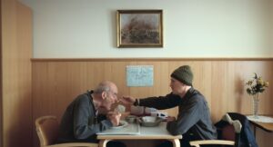 Un adulto mayor con un adulto en una cafetería