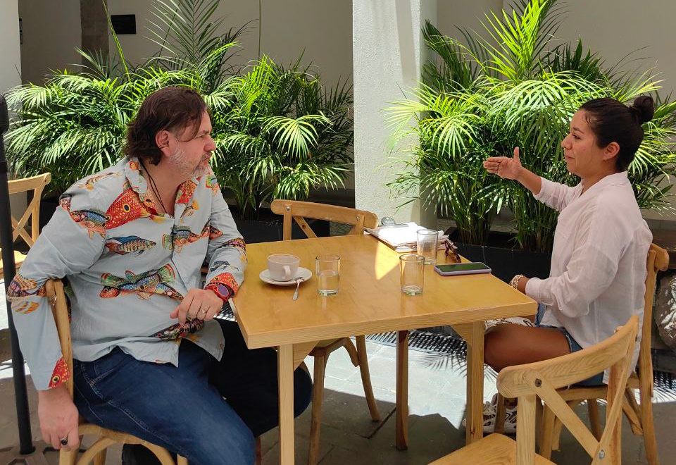 Un hombre y una mujer platicando en una mesa