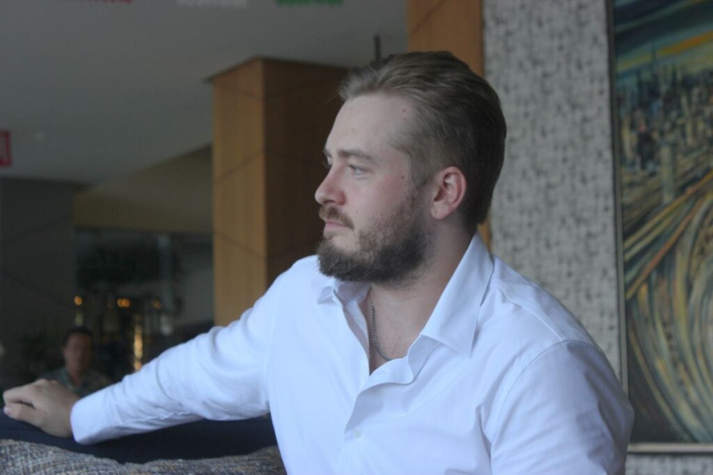 Hombre joven de perfil con barba camisa blanca