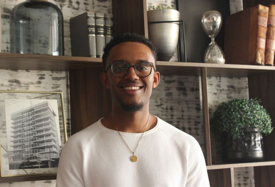 Hombre sonriendo con lentes y collar