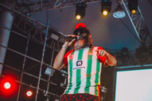 Hombre cantando micrófono en la mano playera de futbol