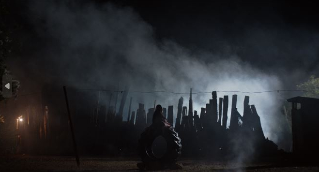 Terreno en la oscuridad de noche con tablas y una llanta en medio