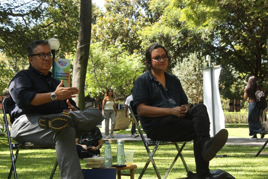 Dos hombres sentados en parque piernas cruzadas