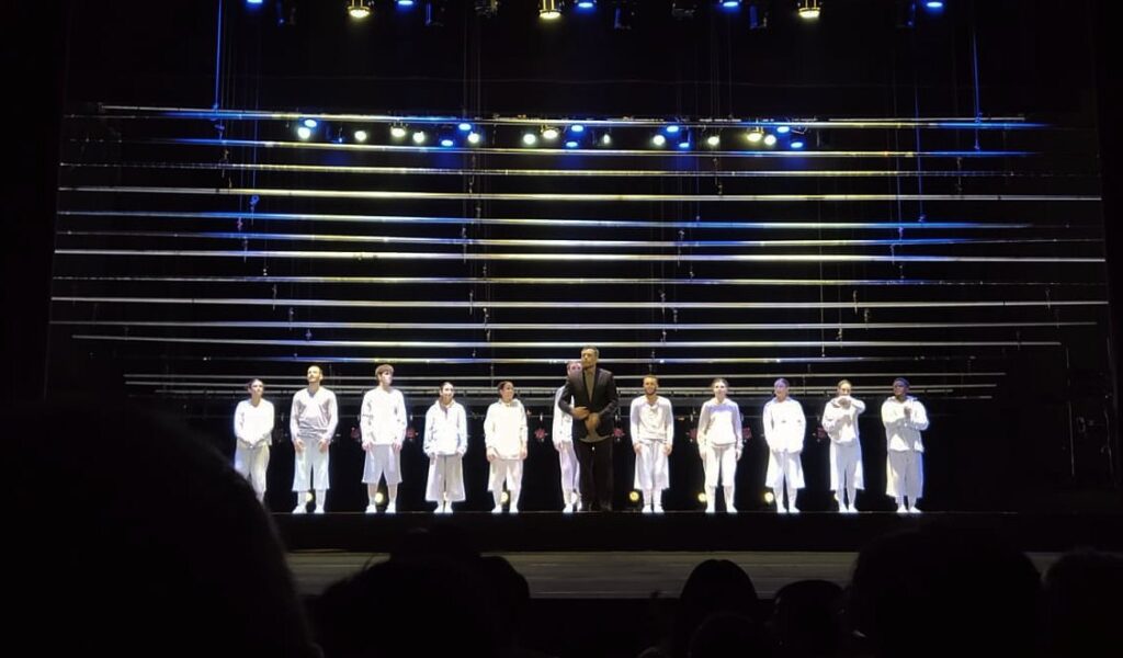 Víctor Quijada Personas hombres y mujeres tomados de la mano en teatro ropa blanca y negra