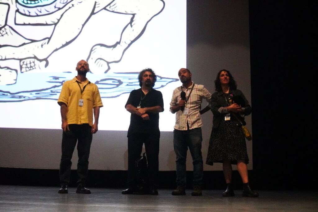 Cuatro personas: tres hombres y una mujer de pie