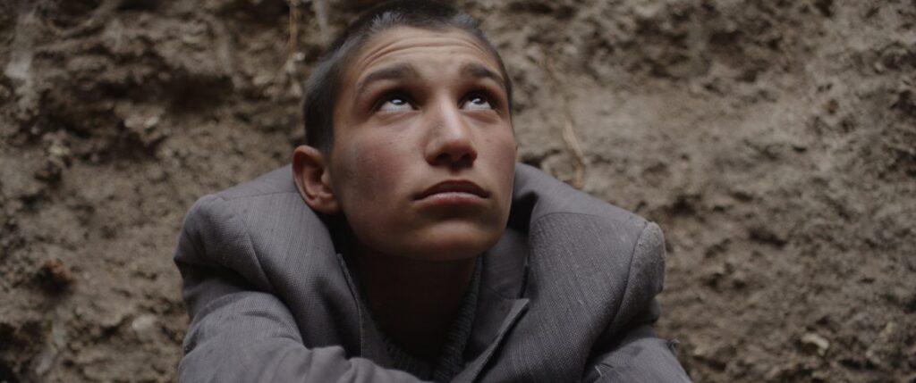 Niño mirando hacia arriba dentro de cueva