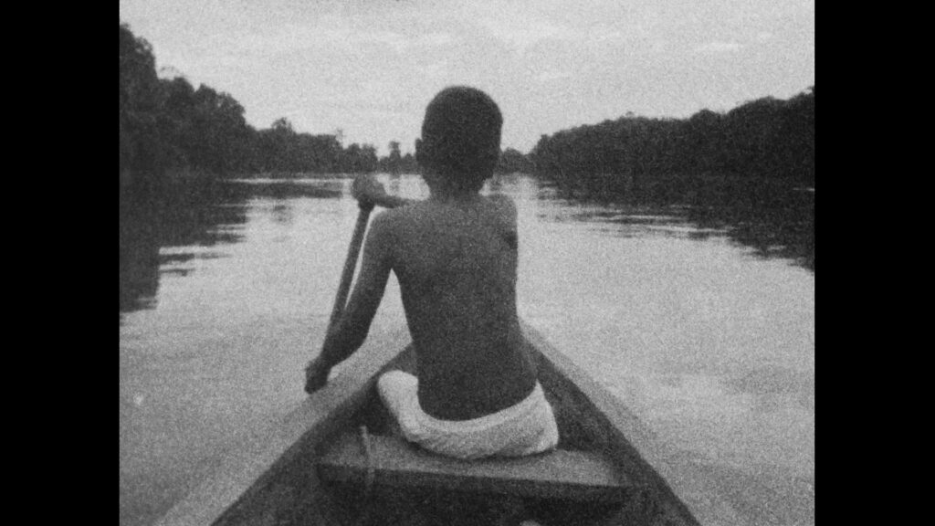 Fotografía antigua niño en canoa remando en un río