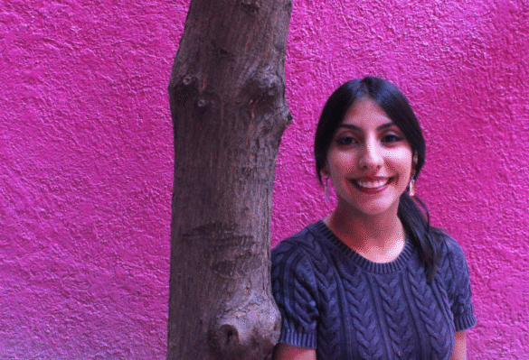 Larrisa Rú mujer joven cabello largo recargada en un árbol fondo morado