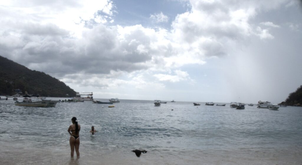 Mar y cielo con nubes hay una persona en la playa