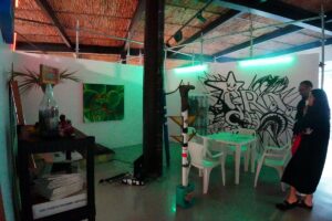 Habitación colchón, mesa y sillas blancas, grafity y cuadro en la pared