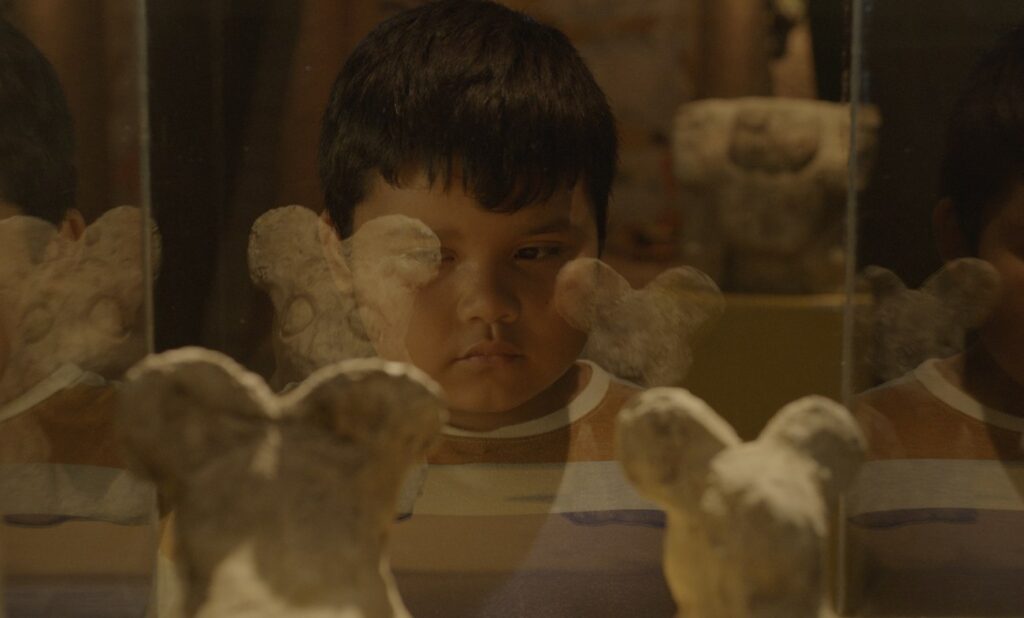 Niño viendo estatuas pequeñas en forma de ratón