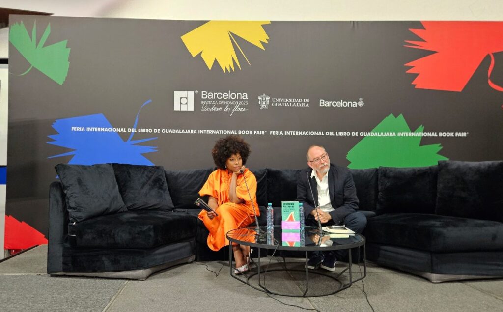 Chimamanda Ngozi Adichie mujer y hombre sentados en rueda de prensa