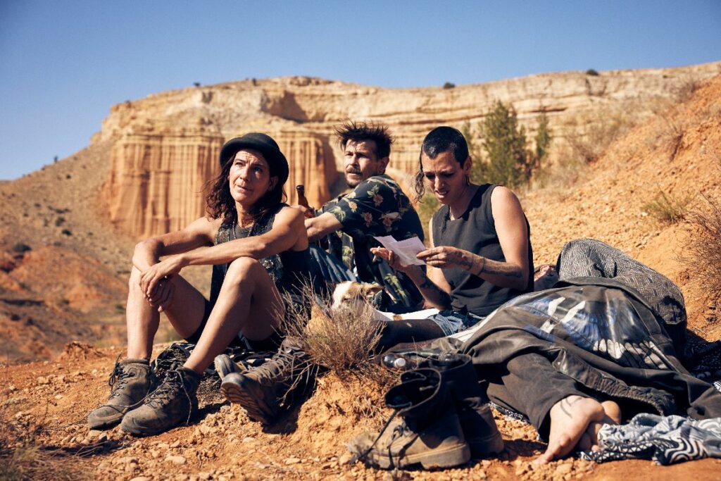 Cuatro personas adultadas en el desierto sentadas