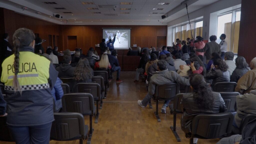 Personas en una conferencia sentadas en sillas viendo pantalla